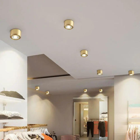 8 Pack Top Tier Recessed Lighting With Rock Solid Brass Trim And Super Bright 9W Directional Downlights in retail store ceiling.