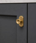 Antique Brass Cabinet Knobs With Backplate 6 Pack Solid Zinc Alloy Single Hole Center Pull Handles For Kitchen And Bedroom Upgrades. Knob mounted on dark cabinetry.