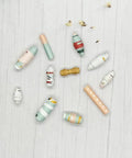 Large Paper Beads Maker Dies And Stencils For DIY Scrapbooking And Card Making, showcasing colorful paper beads on a wood table.