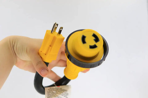 Hand holding 30 Amp RV To Household Power Adapter Dogbone Twist Lock To 15 Amp 110 Volt Converter with yellow plugs