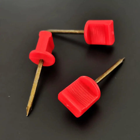 Close-up of 20Pack Archery Target Pins heavy duty manganese steel nails with red plastic heads on black background