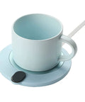 Compact Desk Coffee Warmer With Auto Shut Off And Waterproof Aluminum Base, blue cup and base on a work desk.
