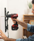 Man using 12V Cordless Drill Driver And One Quarter Inch Hex Impact Combo Kit With Two 2.0Ah PW Core 12 Batteries for wall installation.