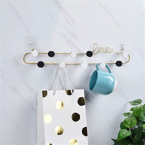 Heavy Duty Wrought Iron Love Shaped Wall Hooks Sturdy Coat Rack Row keeps essentials on decorative gold rack with colorful accents.