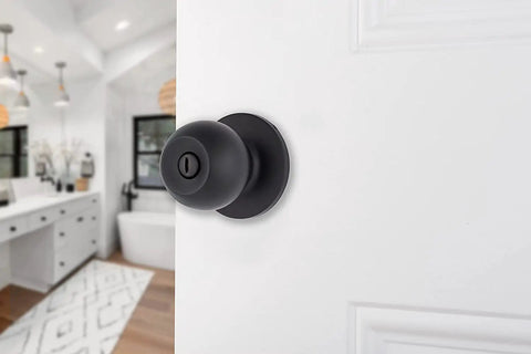 Transitional Privacy Door Knob Set In Matte Black For Exterior Doors With Lock, installed on an open white door