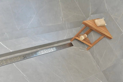 Top Tier 60 Inch Linear Shower Drain With Side Outlet Brushed Nickel Stainless Steel Hair Catcher Strainer Grate For Wet Room Bathroom Floor, installed over gray tiles.