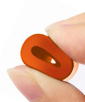 Close-up of an orange silicone bed mount held between fingers, featured in Upgrade Your Rig With Built Tough Silicone Bed Mounts And Heavy Duty Leveling Springs That Deliver Flawless Prints Every Single Time For Ender 3 Max Cr10 Sv01 Sv02 Fdm Printer Accessories.
