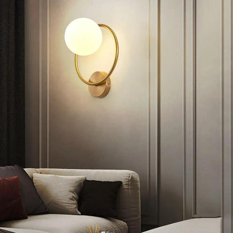 Modern Luxury Sphel Glass lampshade Wall Sconce 9.0 Inch Width den Iron Body Wall Lamp with 3 Color Mode Indoor Lighting Fixture for Bedroom Living Room Study Hallway on a beige wall.