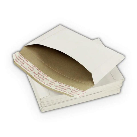 Stack of Rigid 6.5 By 4.5 Inch Photo Mailers White Cardboard Stay Flats With Peel And Stick Adhesive showing opening and adhesive strip