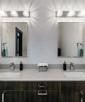 Modern bathroom with two mirrors, stylish lighting, gray countertop, and white vessel sink on dark cabinetry.