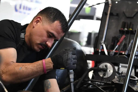 Mechanic using Specialty Grip Work Gloves With Secure Fit And High Traction For Dry Oily And Wet Conditions Large Black Grey Anti Slip Durable Hand Protection For Builders Technicians And DIY Pros while working on machinery.