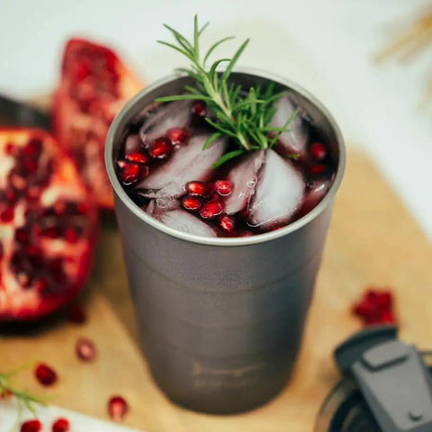 Close-up of 16 Oz Triple Vacuum Insulated Stackable Tumbler With Leak Proof Screw Top Lid featuring ice and pomegranate seeds.