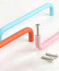 Colorful cabinet pull handles with screws, showcasing pastel blue, orange, and pink curved designs with visible mounting screws.