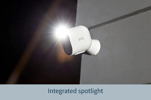 Pro 4 Spotlight Camera 1 Pack Wireless Home Security With 2K HDR Video Color Night Vision 2 Way Audio Direct To WiFi No Hub Needed Renewed White Plus Smart Alerts And Quick Phone Notifications mounted on wall with spotlight on.