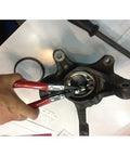 Close-up of CTA Tools 4028 wheel bearing lock ring pliers with red handles gripping a hub bearing lock ring