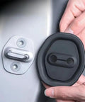 Hands installing Rock Solid Silicone Car Door Lock Cover on Nissan Rogue door latch, black silicone guard for moisture protection.