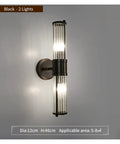 Modern Black Wall Sconces Bring A Smooth Chill Vibe With Classic Glass Shades Perfect For Bedroom Bedside Living Room Or Hallway Decor Glare Free Minimalist Indoor Lighting Solid Build Zero Hassle Setup, featuring two lights and cylindrical glass shades.