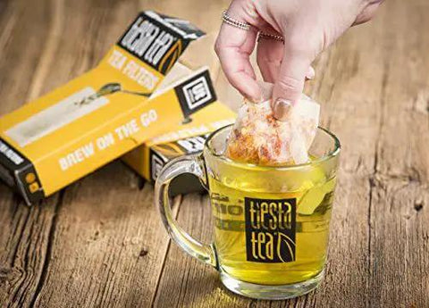 Disposable Loose Leaf Tea Filters For Easy Brewing, Unbleached Paper Sachets used in glass mug, 100 Empty Bags displayed
