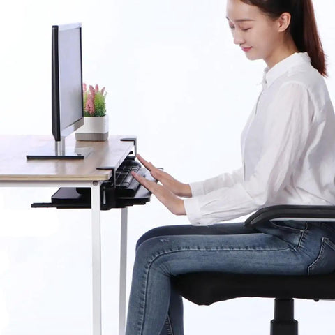 User typing on the Rock Solid Retractable Keyboard Tray with slick pull-out action, under a desk, in a clutter-free setup.