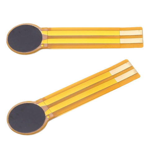 Two FLEXMAN thin-film pressure sensors with round black sensing pads and yellow flex circuits.