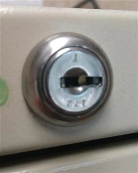 Close-up of a filing cabinet lock, highlighting custom cut file cabinet and cubicle desk replacement key that goes like a charm.