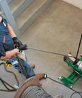 Electrician using Greenlee Ut10 Pulling Package with heavy duty floor mount for wire handling in a commercial setting.