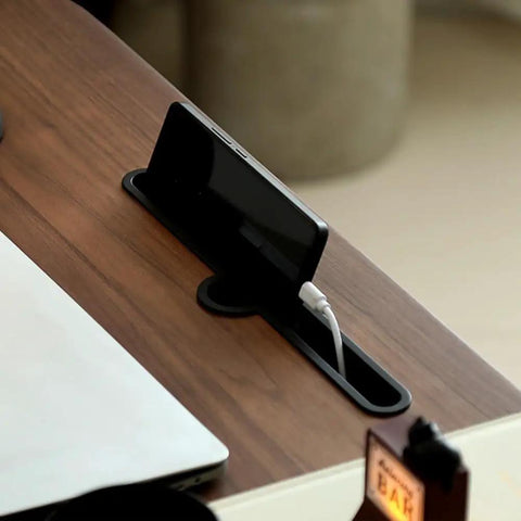 Upgrade Your Home Office Setup With This Smooth Riding Mobile Standing Desk That Dials In Your Perfect Height Fast For Seamless Sit Or Stand Flexibility Wherever You Roll. Phone resting in cable management slot on wooden desk.