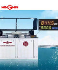 Front view of waterjet cutting machine with open hood and digital control panel readouts.