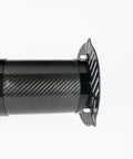 Carbon fiber cylindrical object with vented end cap, close-up angle on smooth textured surface and slotted design.