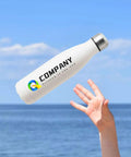 Snag Our Fly Custom 17 Oz Insulated Water Bottles With Double Wall Stainless Steel Build Plus Leak Proof Reusable Design Great For Sports Travel And Gym Workouts White Bulk 100 Pack Holds One Hundred Cups Ideal Kick Back Drinkware Vacuum Sealed held by hand against a blue ocean background.