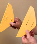 Hands holding the POPeeze Popcorn Ceiling Scraper Vacuum Attachment blades for shop vacuums, acoustic texture removal tool.