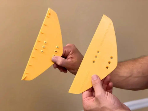 Hands holding the POPeeze Popcorn Ceiling Scraper Vacuum Attachment blades for shop vacuums, acoustic texture removal tool.
