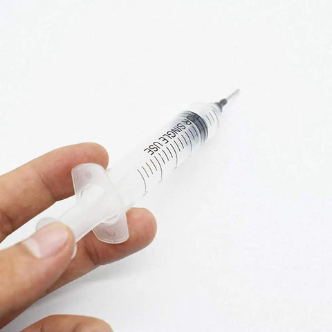 Person holding a single syringe from the Three 10cc Syringe SMT SMD PCB Solder Flux Paste Adhesive Glue Liquid Dispenser Set With Needle Caps