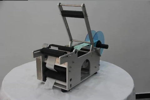 Semi Auto Round Bottle Labeling Machine For 15-30 Pcs Per Minute Speed with aluminum alloy frame and label rolls.