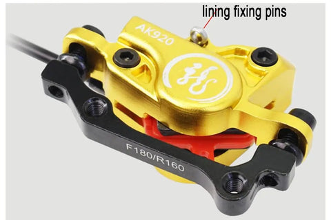 Close-up of Heavy Duty Hydraulic Disc Brake Set Front And Rear With Two Piston Aluminum Calipers, gold finish.