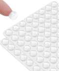 2 Pack Self Adhesive Bumpers 1/2 Inch Diameter Clear Round Cushions 64 Pieces for Cabinets, shown on sheets and fingertip.