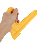 Hand holding a yellow ergonomic push block for woodworking safety, part of the Badass Two Pack V Shaped Push Blocks.
