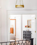 Top Shelf Four Light Ceiling Pendant Crafted From Solid Brass And Alabaster Stone Shades Featuring Aged Brass Finish Adjustable Chain For Bathrooms, hanging in a hallway.