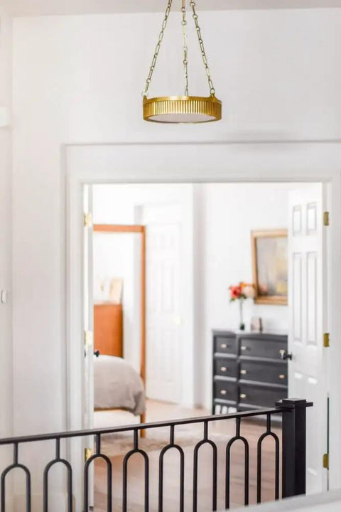 Top Shelf Four Light Ceiling Pendant Crafted From Solid Brass And Alabaster Stone Shades Featuring Aged Brass Finish Adjustable Chain For Bathrooms, hanging in a hallway.