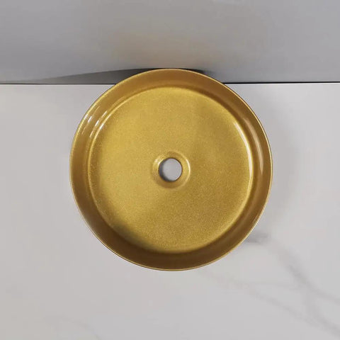 Top view of round golden counter basin, a sleek bathroom sink perfect for modern art designs in hotel apartments.