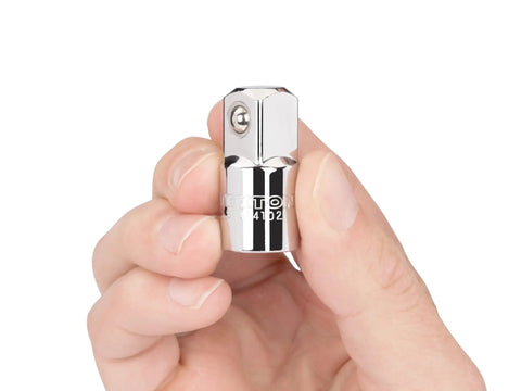 Hand holding three eighths inch drive to half inch drive adapter with beveled end and chrome plated finish for easy alignment