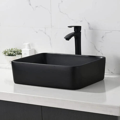 Black rectangular ceramic sink with faucet on white countertop, modern bathroom design