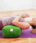 Rectangular Yoga Bolster Pillow For Restorative Yoga And Meditation, Extra Firm Cotton Cushion That Props Hips, Knees, And Back, Large Floor Pillow 28 By 12 By 8 Inches For Home Practice And Meditation. Woman using green cotton bolster for supported backbend