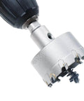 Close-up of a 2-inch metal hole saw with carbide teeth mounted on a drill chuck