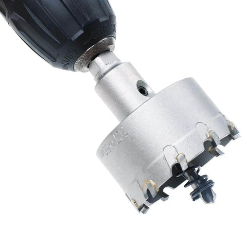Close-up of a 2-inch metal hole saw with carbide teeth mounted on a drill chuck