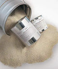 Quick Setting Epoxy Concrete Floor Patch Two Gallon Light Gray Rapid Cure Mix spilling from a tin can.
