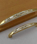 Top Shelf European Style Real Gold Tone Cabinet Pulls 128mm Heavy Duty Drawer Handles And Wardrobe Knobs Sharp Palace Design close-up on wooden surface.