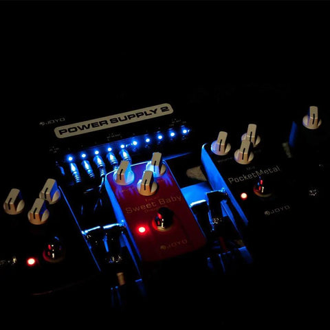 Guitar Pedal Power Supply with 10 Isolated Outputs 9V 12V 18V Options powering distortion stompboxes on a pedalboard.