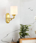 Solid Brass Wall Sconce With Smooth White Glass Shade Modern E27 Light Fixture on wall beside plant near sofa.