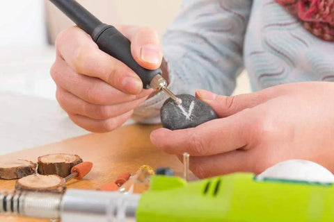 Hand engraving stone with Pro Grade Diamond Burr Bits Drill Kit For Rotary Tools 90 Piece Set in use